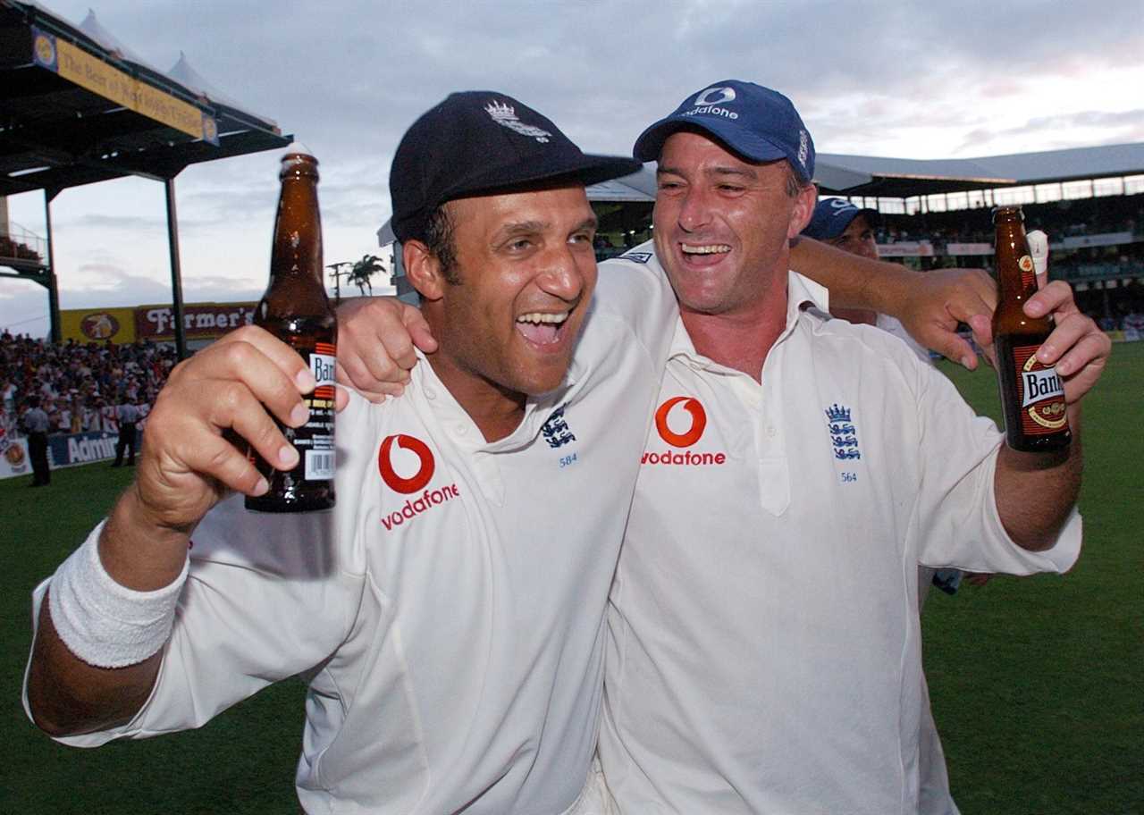 two men holding beer bottles one of whom is wearing a vodafone shirt