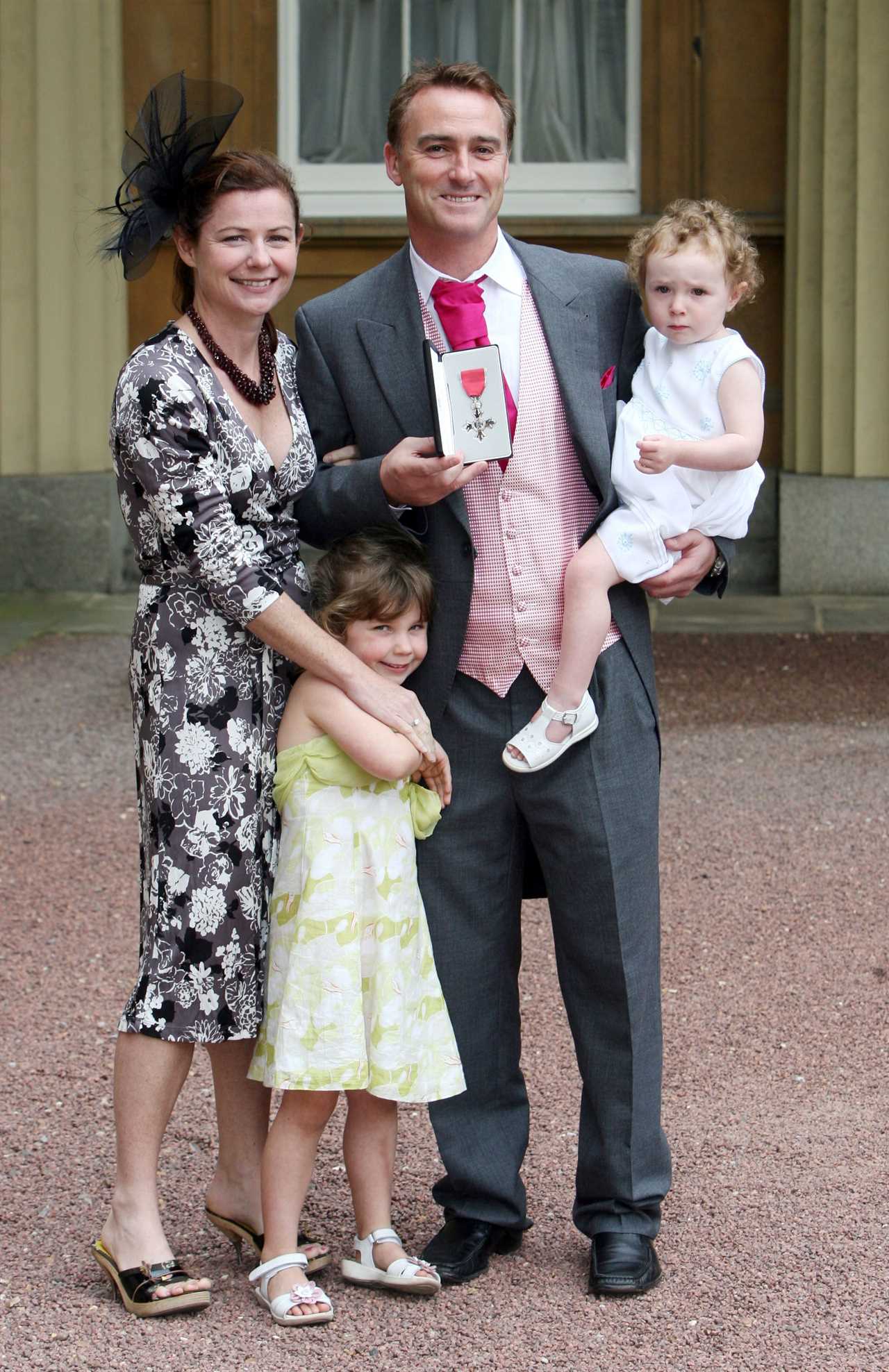 a man in a suit is holding a medal with a cross on it