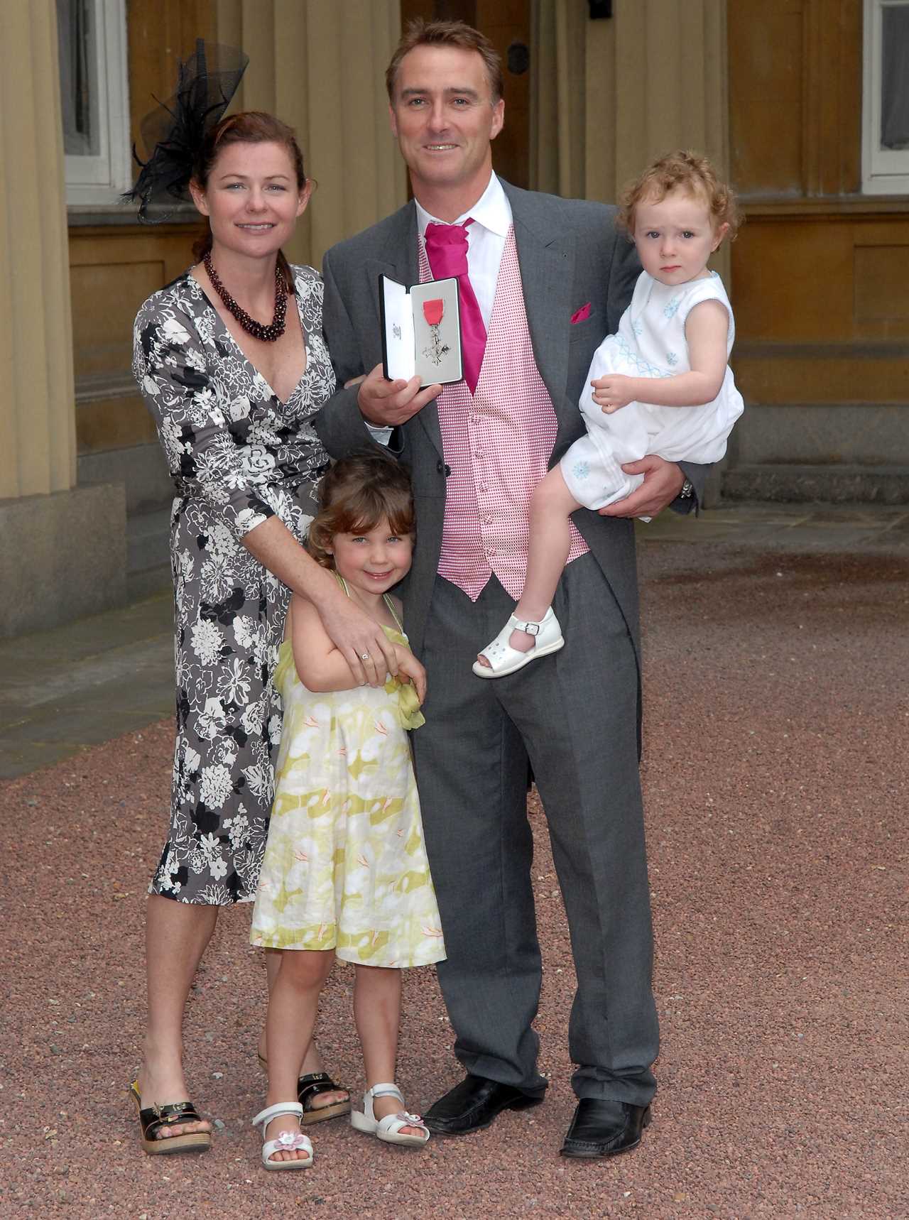 a family posing for a picture with a man holding a medal