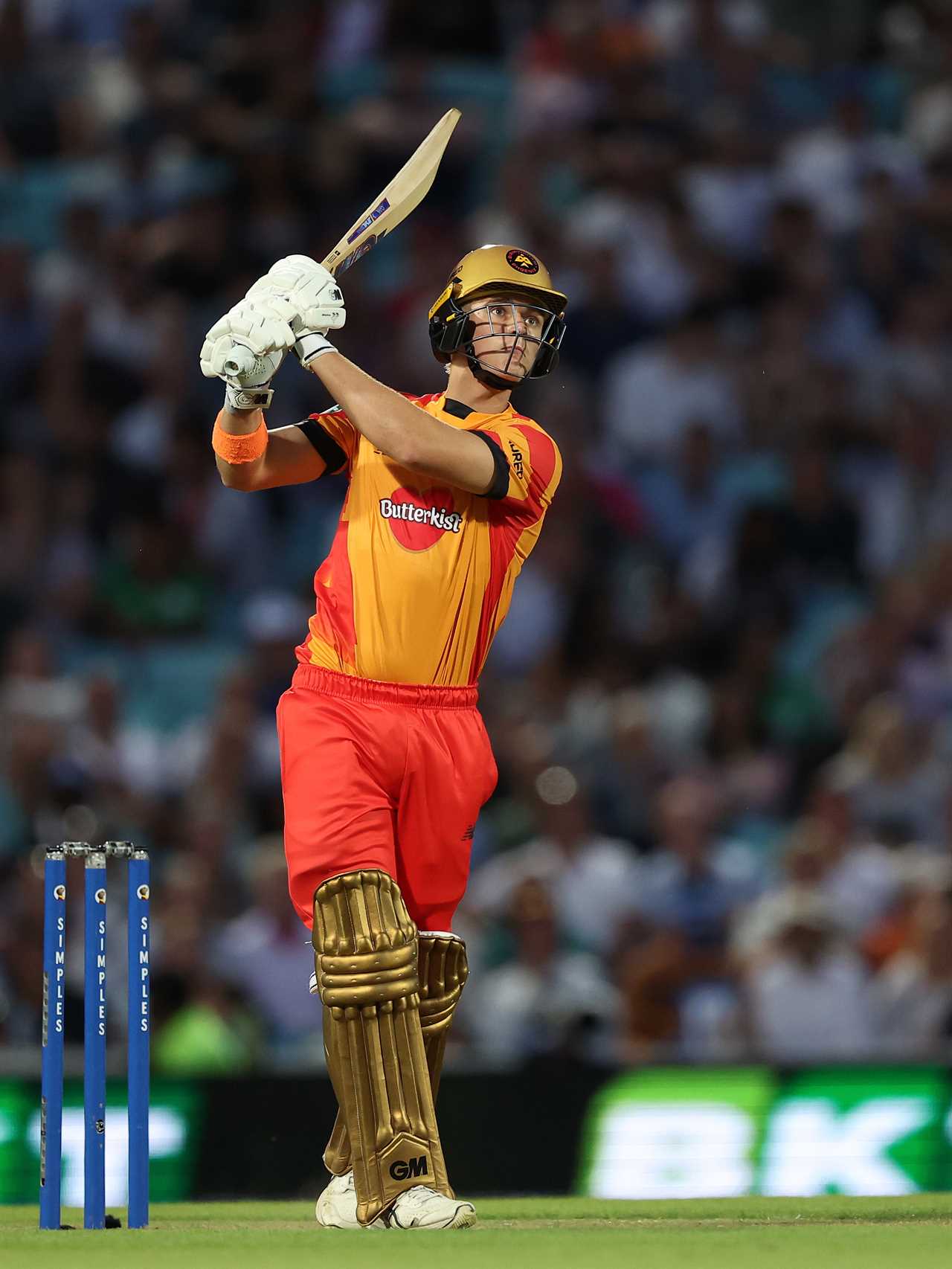 a cricket player wearing a jersey that says butterkist