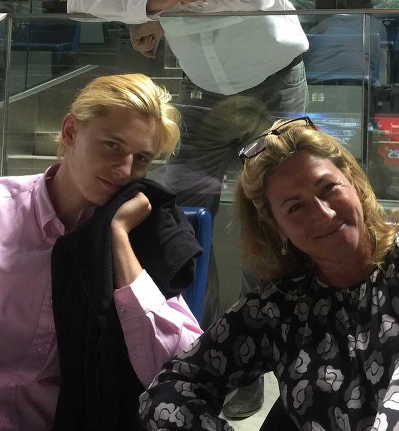 a woman and a boy are posing for a picture in front of a pepsi sign