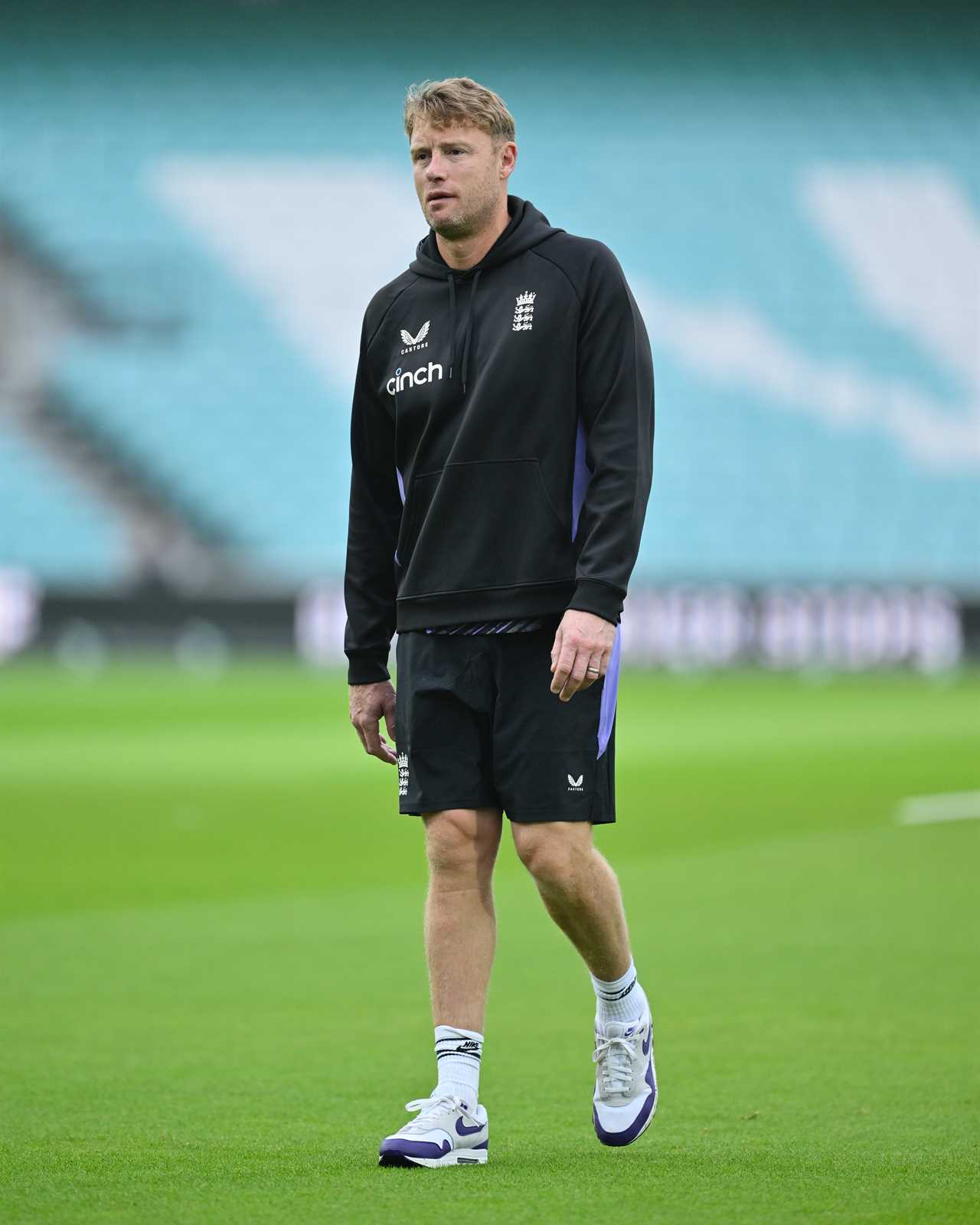 a man walking on a field wearing a sweatshirt that says dinch