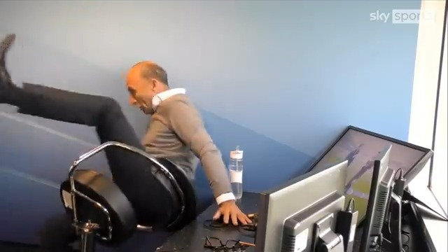 a man is sitting in a chair in front of a computer monitor .