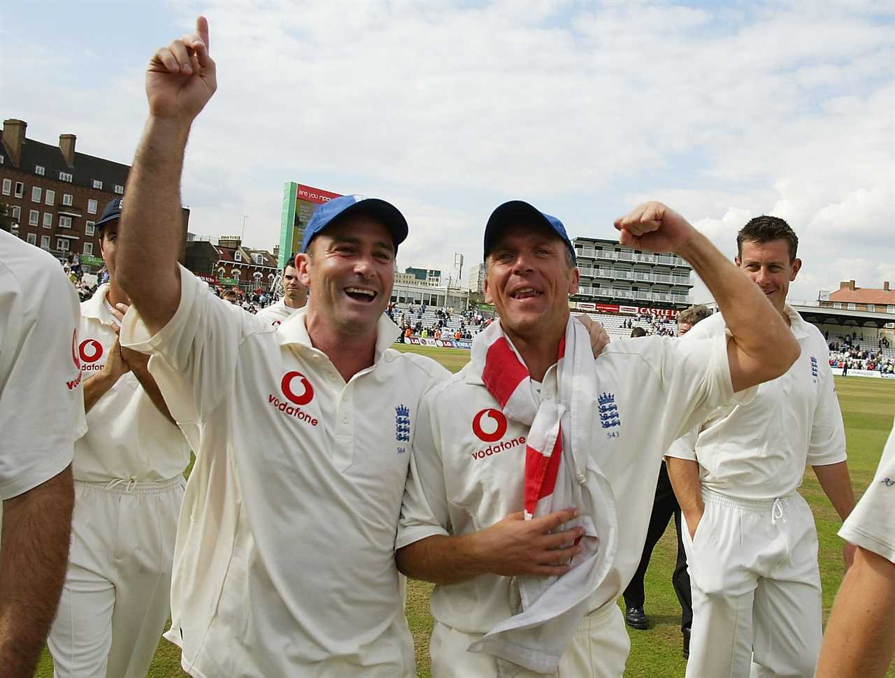 a man wearing a vodafone shirt stands next to another man