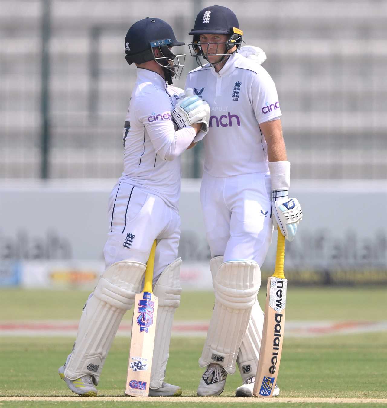 two cricket players one of whom is wearing a cinch shirt