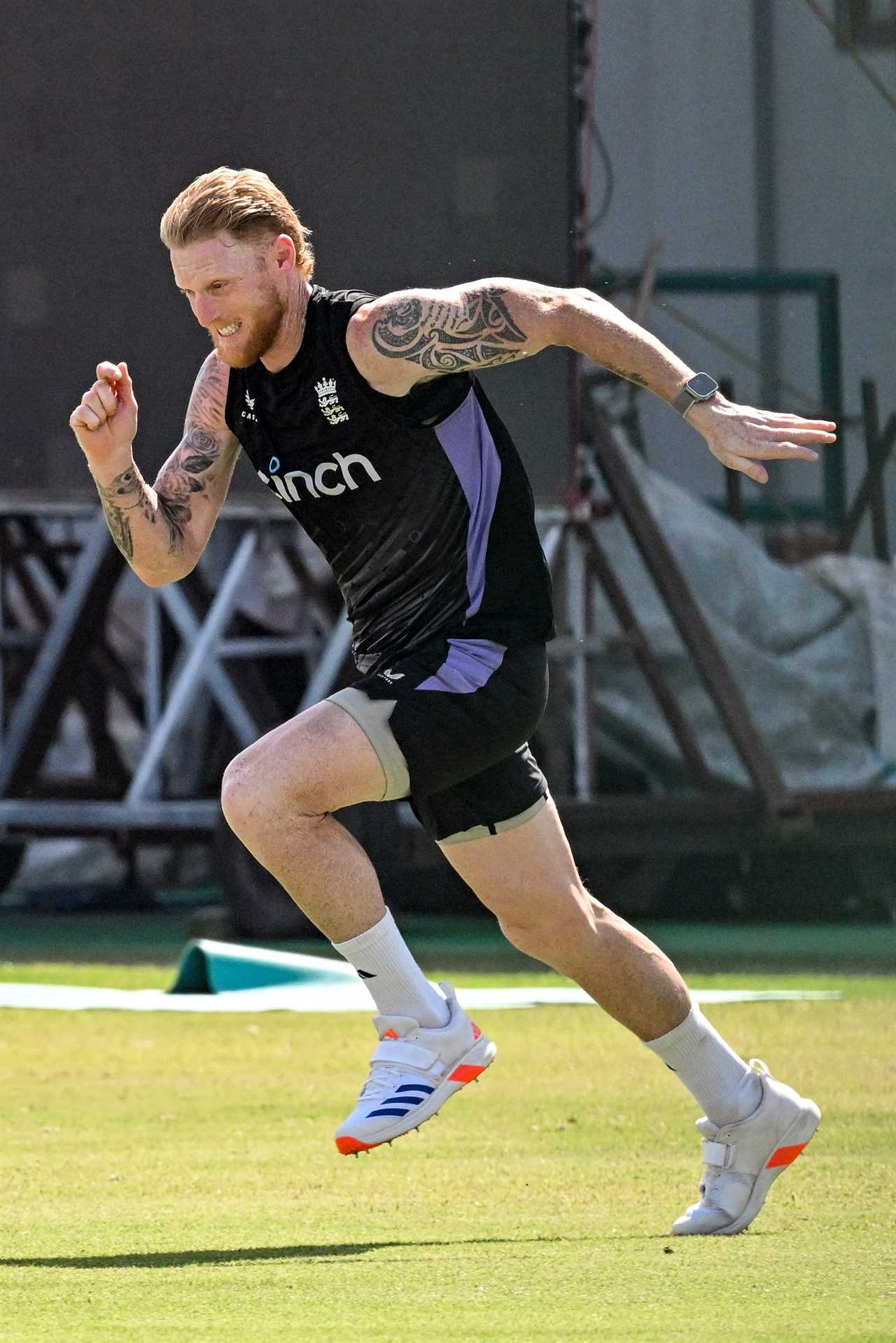 a man wearing a black tank top with the word inch on it