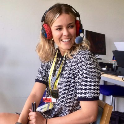 a woman wearing headphones and a microphone is sitting in front of a computer .