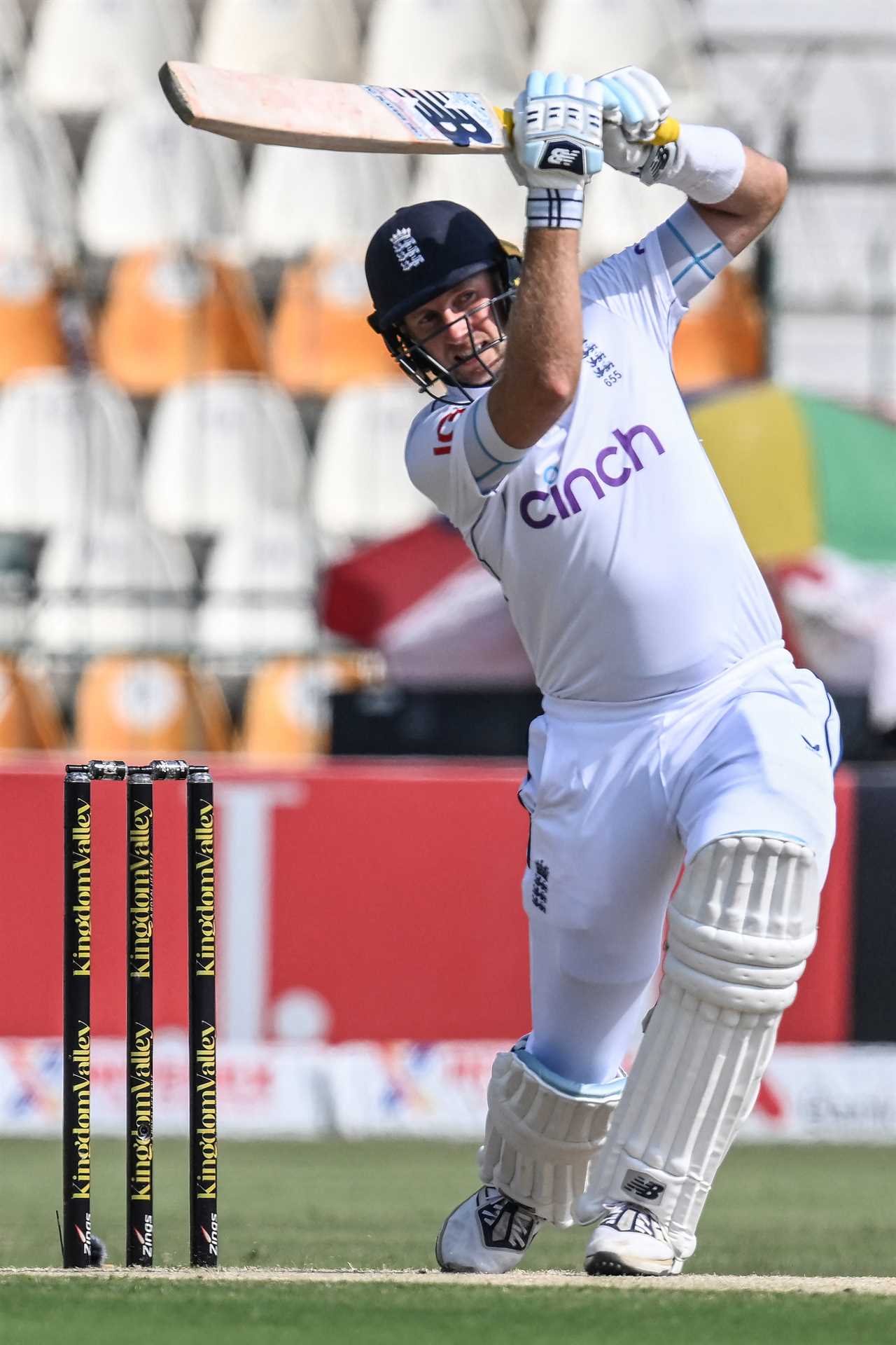 a cricket player wearing a cinch jersey swings his bat