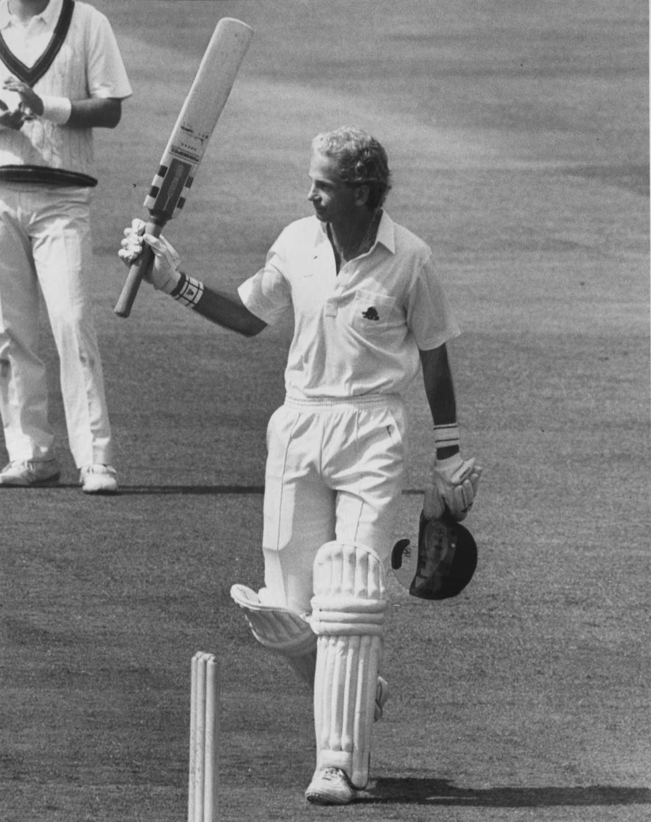 a man holding a bat that says ' slazenger ' on it