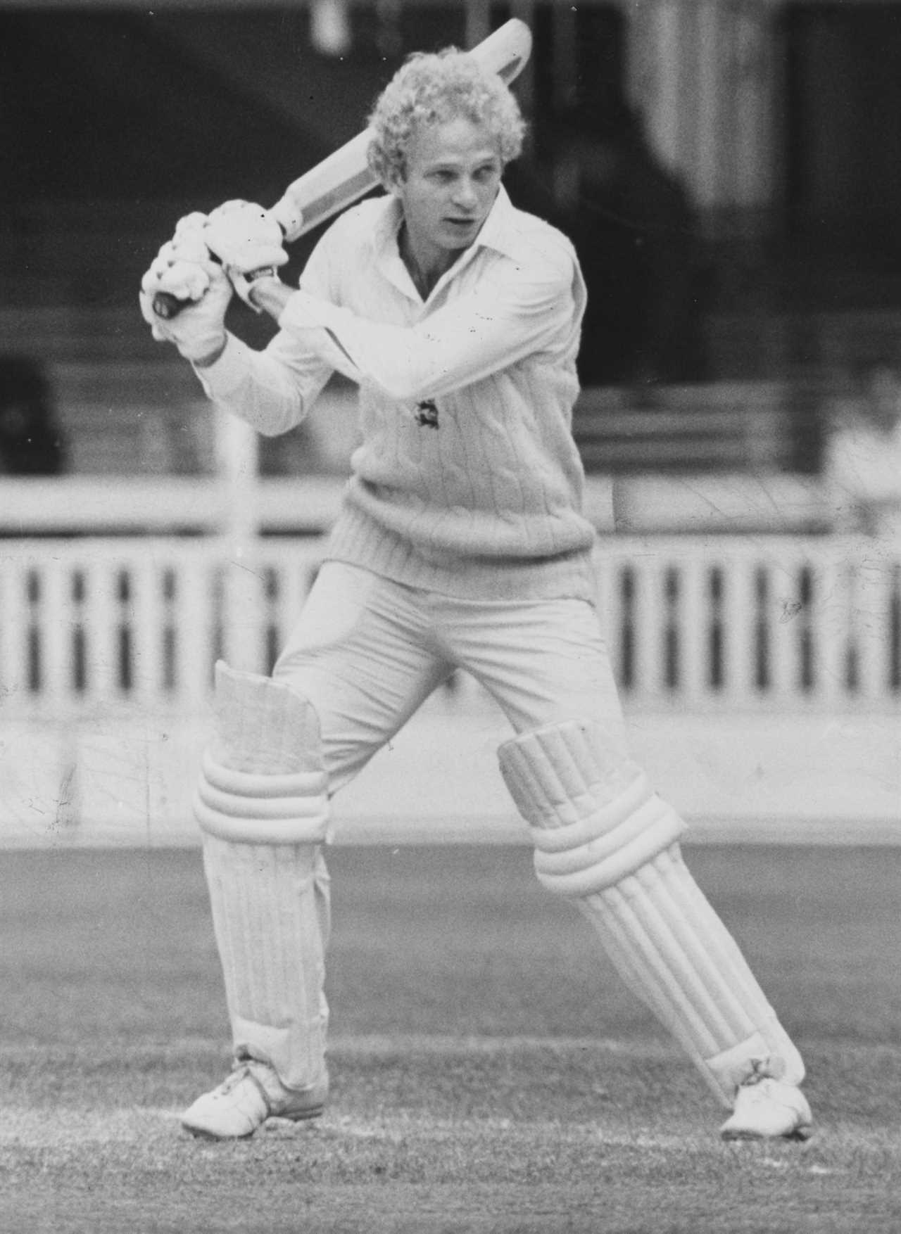 a man in a white sweater is swinging a bat