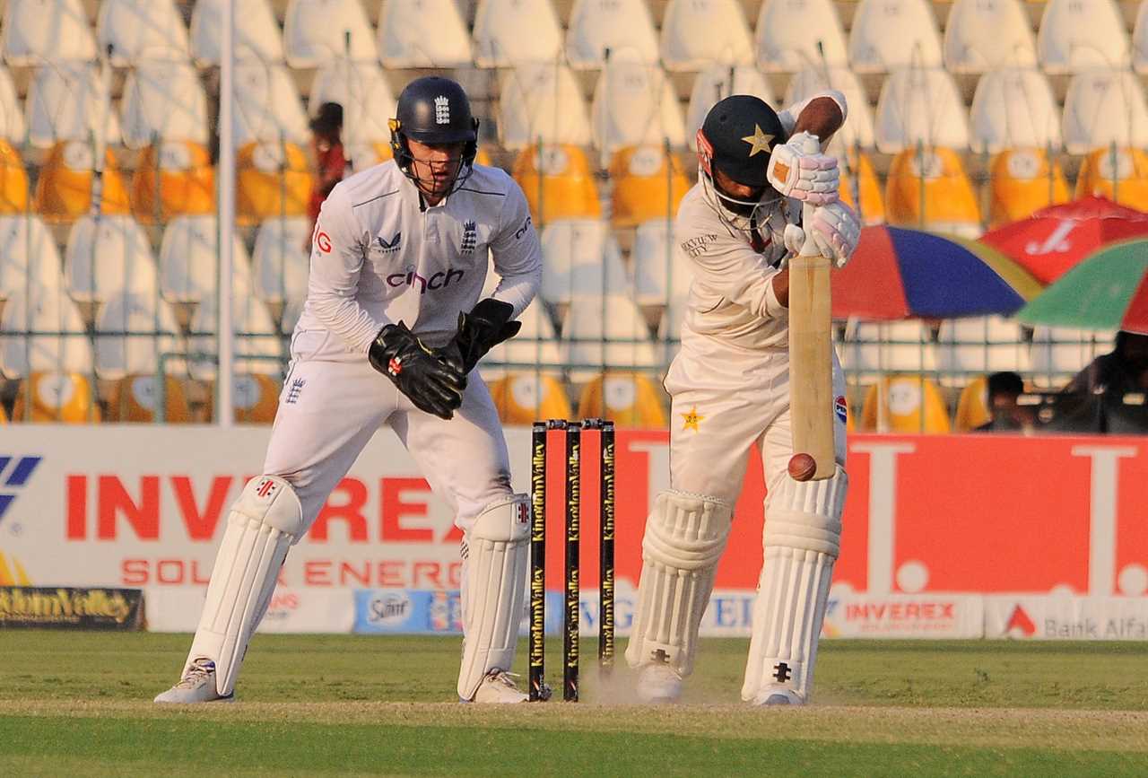 a cricket game is being played in front of an inverex sign