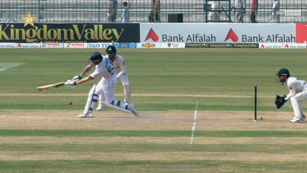 a cricket game is being played in front of an ad for bank alfalah