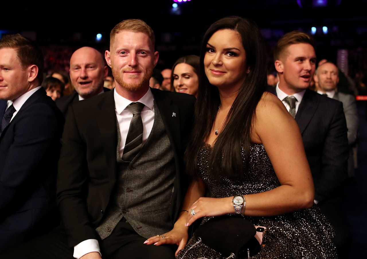 a man in a suit sits next to a woman in a dress