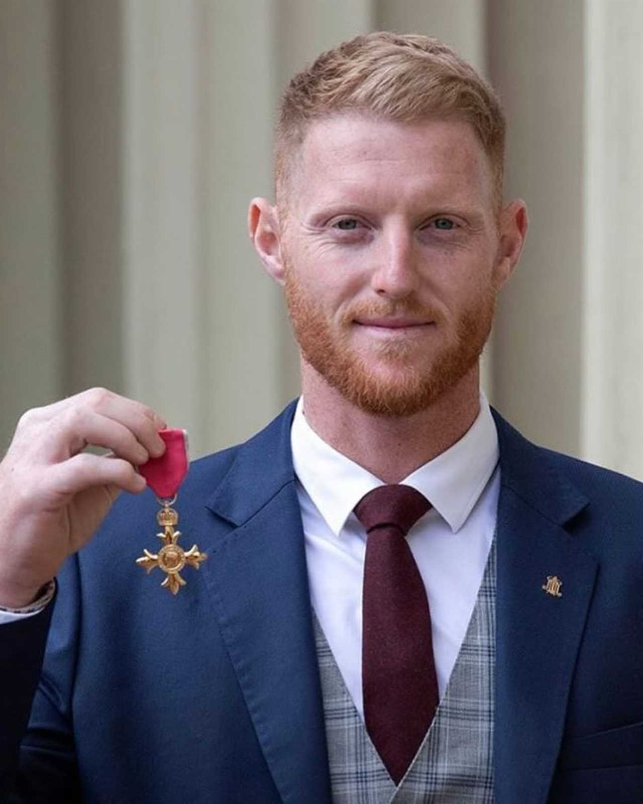 a man in a suit and tie is holding a medal