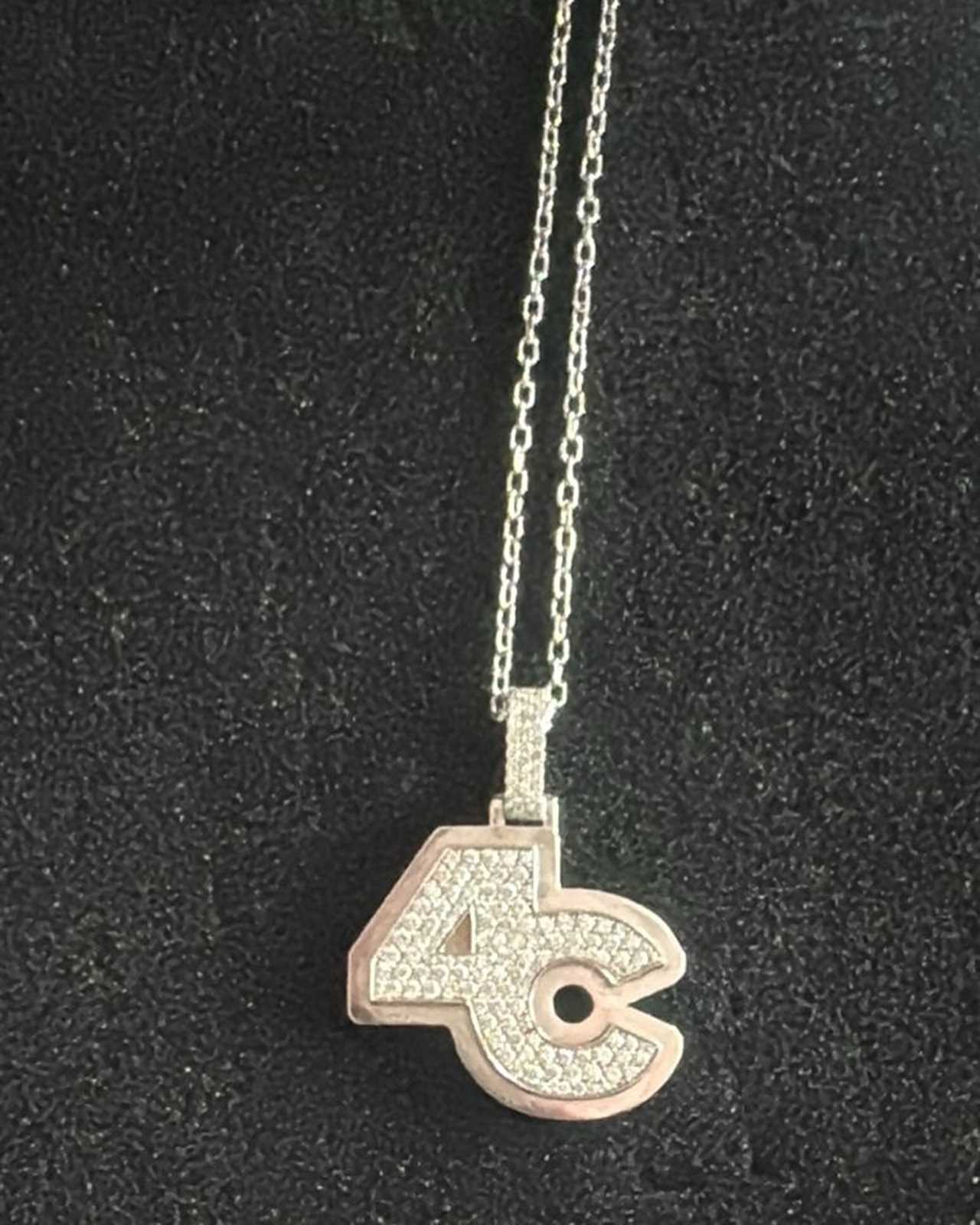 a necklace with a pendant that says ac on it