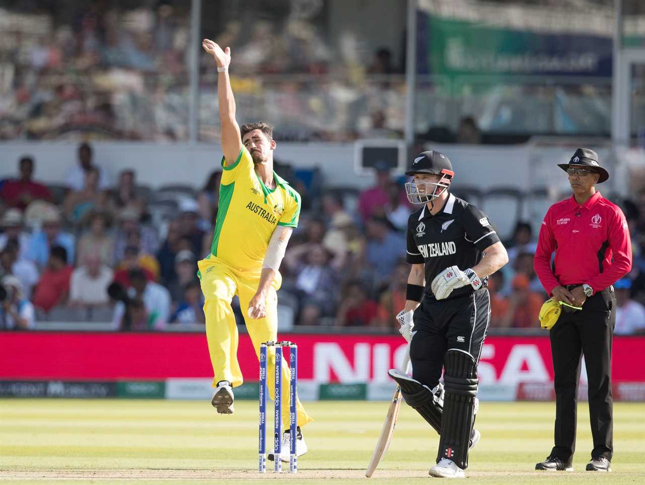 a man in a yellow jersey with australia on it throws a ball