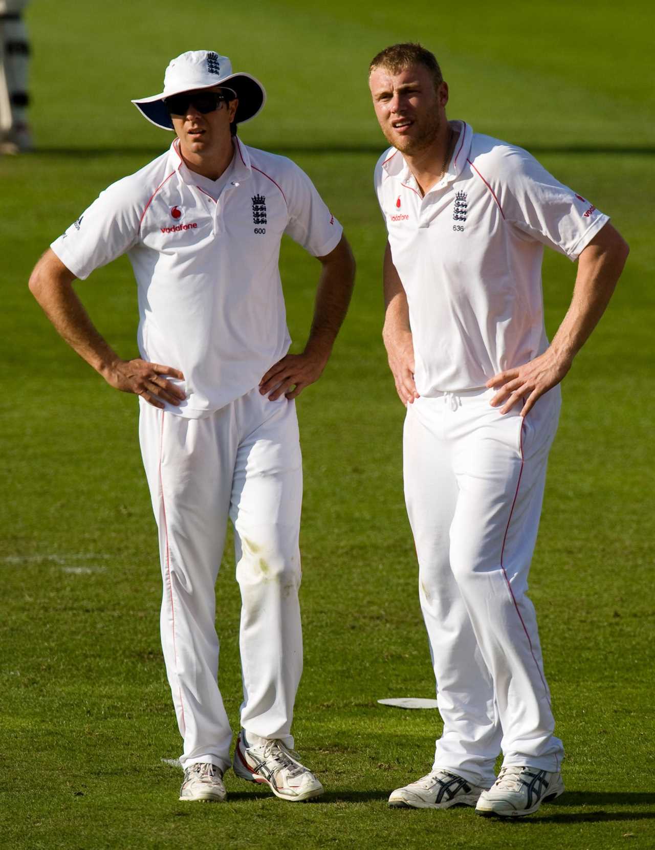 Andrew Flintoff and Michael Vaughan, in white cricket uniforms, await the umpire's decision.