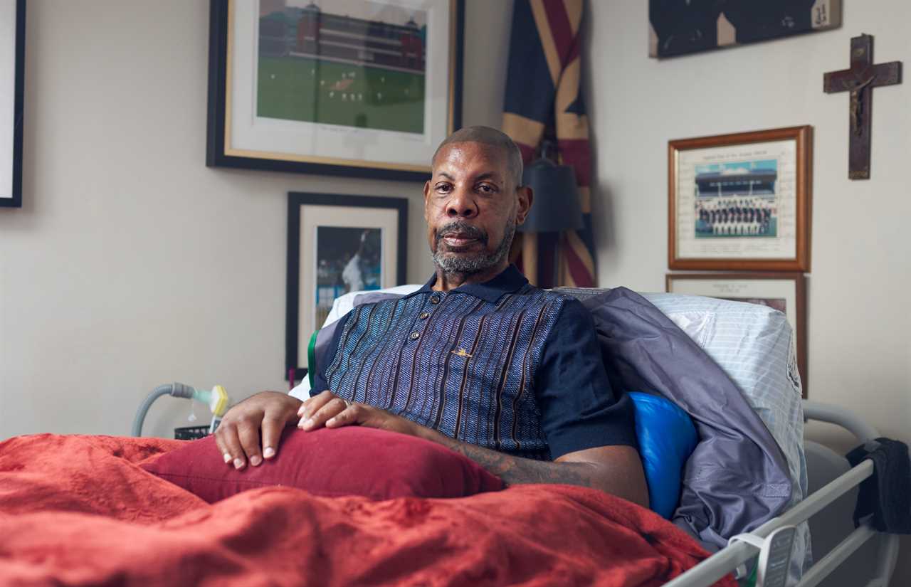 Former cricketer David Lawrence, diagnosed with motor neuron disease, sits in his hospital bed.