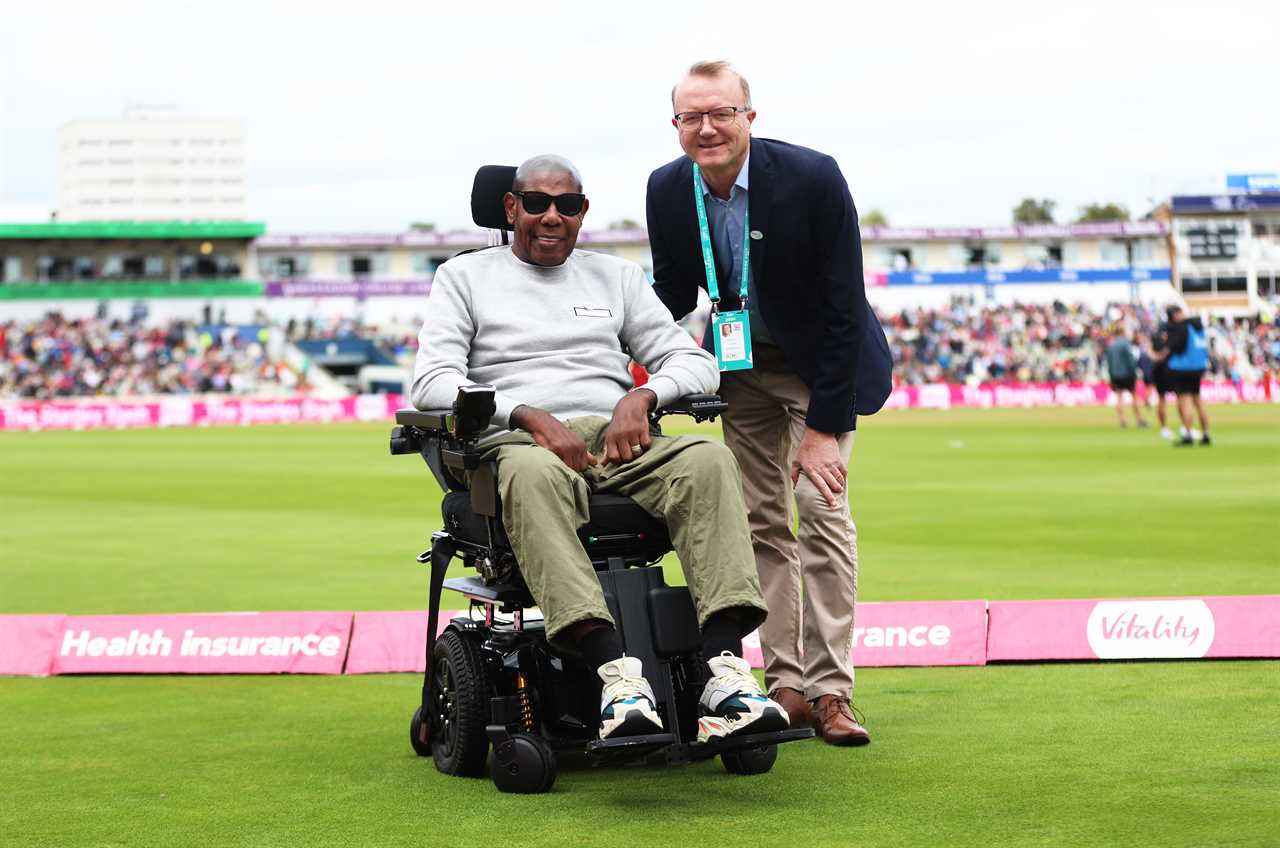 David 'Syd' Lawrence in a wheelchair with Shaun Udal at a cricket match.