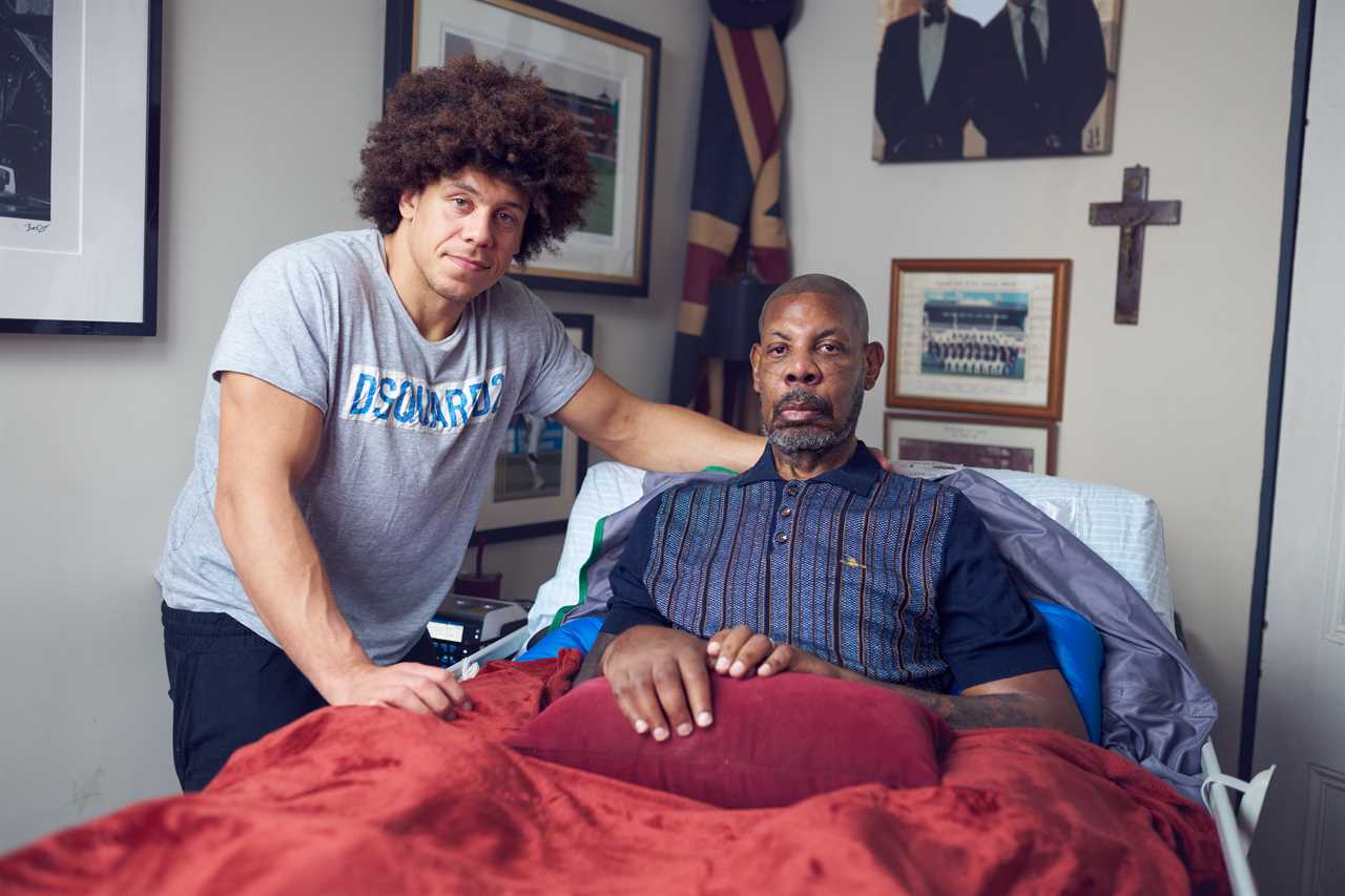 A man sits in bed with his son.