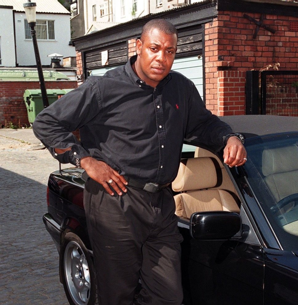 Photo of cricketer David 'Syd' Lawrence leaning against his car after a road rage incident.