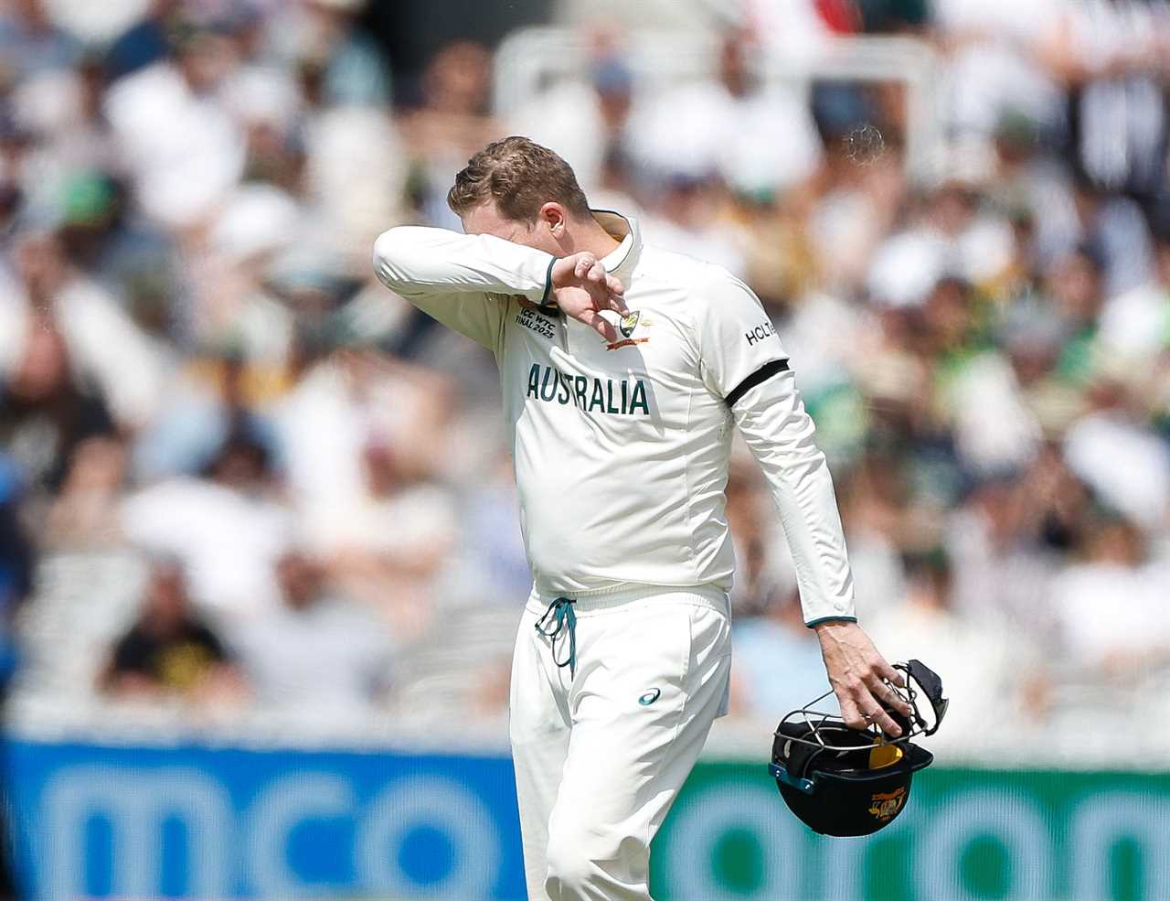 Steve Smith of Australia leaves the cricket pitch in distress.