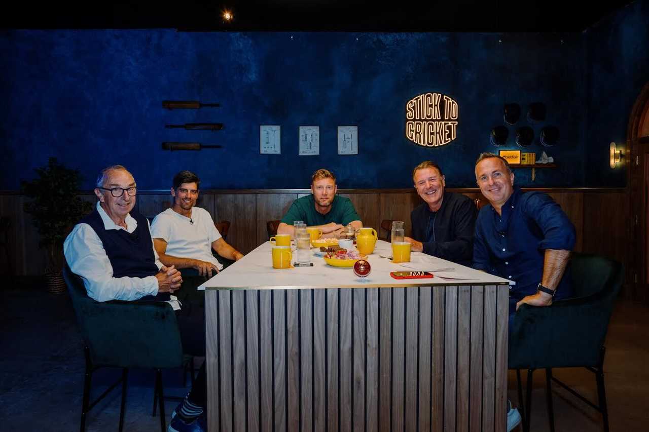 Five men sitting around a table, discussing cricket.