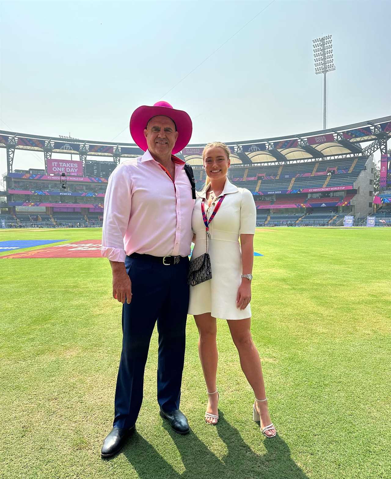 Man and woman standing on a cricket field.