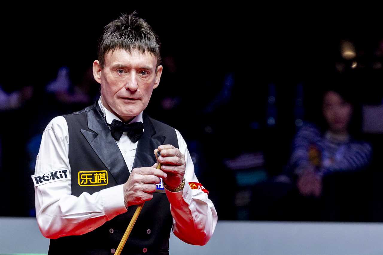 Jimmy White chalking his cue at a snooker match.