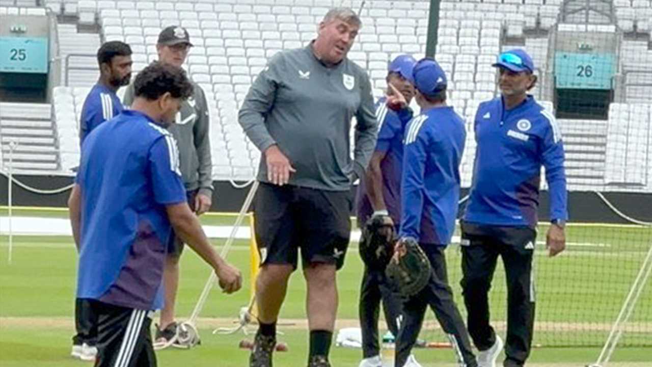 India cricket coach and groundsman on the field.